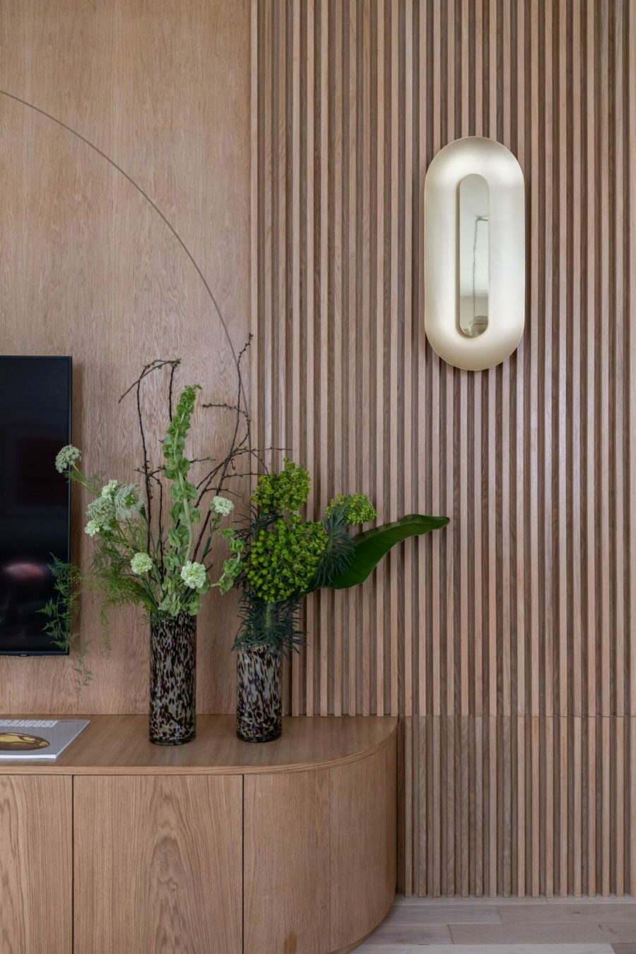 Tasseaux en chêne avec applique MUURA en laiton et meuble TV avec angles cintrés, décoration intérieure sur mesure, Filigrane Design